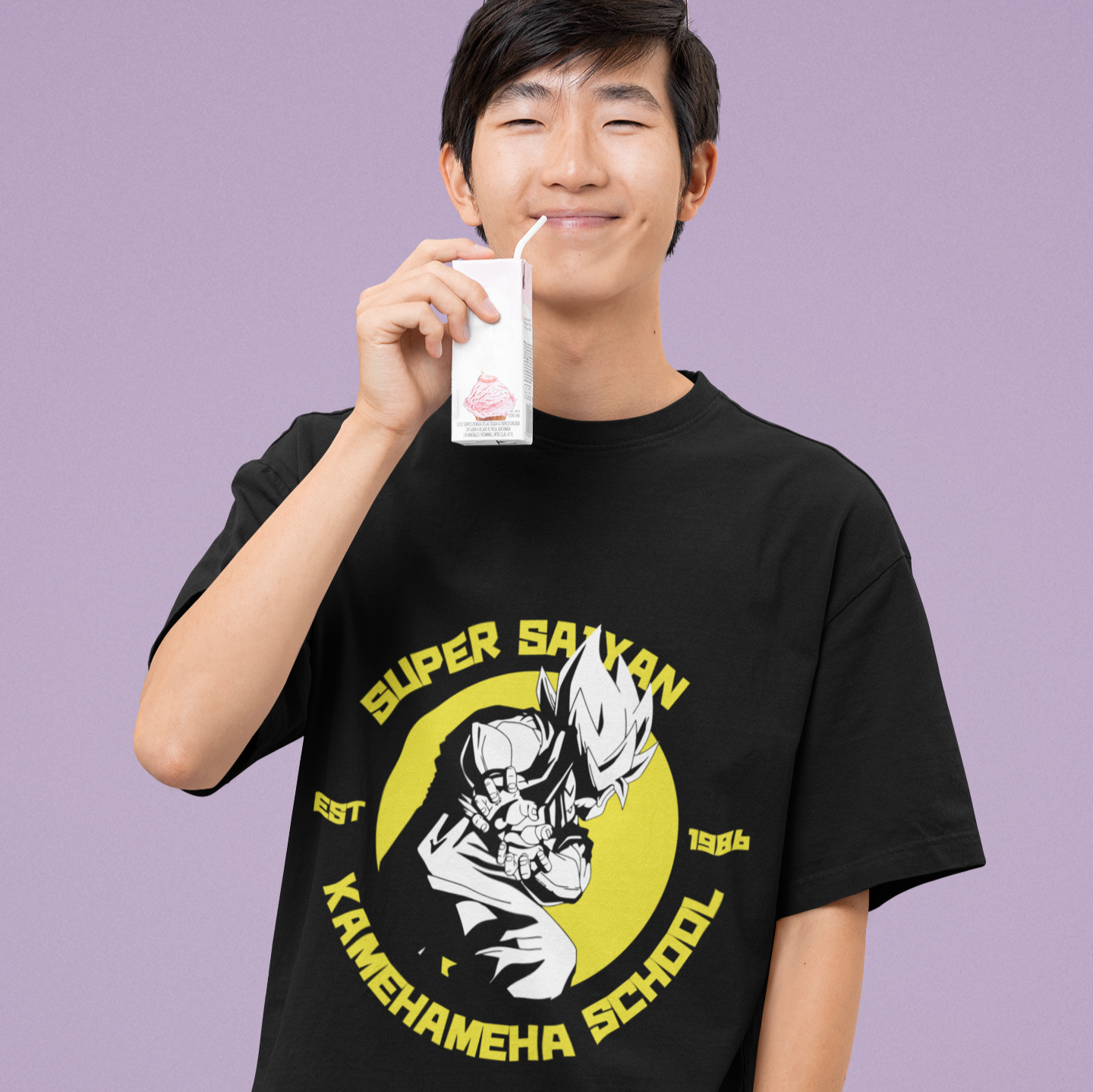 Happy man wearing Super Saiyan Kamehameha School Tee in black drinking from a juice box in a kawaii style.