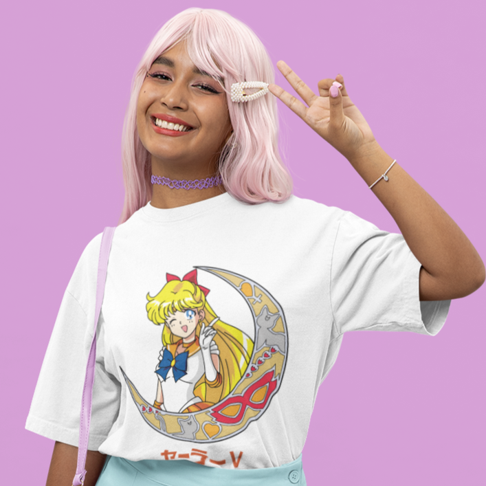 Woman wearing Sailor Venus Crescent Moon Tee in white in making a peace sign and smiling.